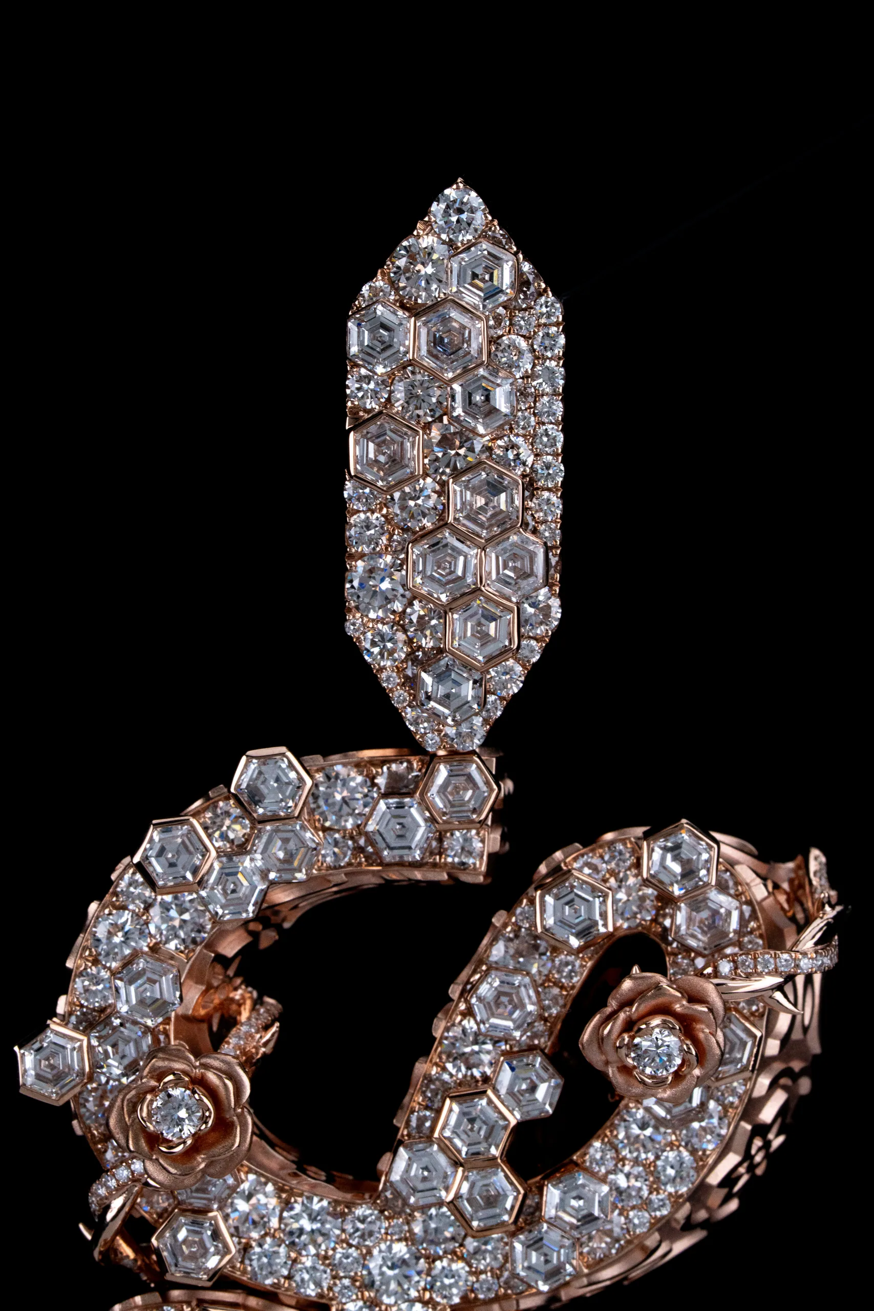 Macro of the diamond pavé following the curve of the rose-gold script.