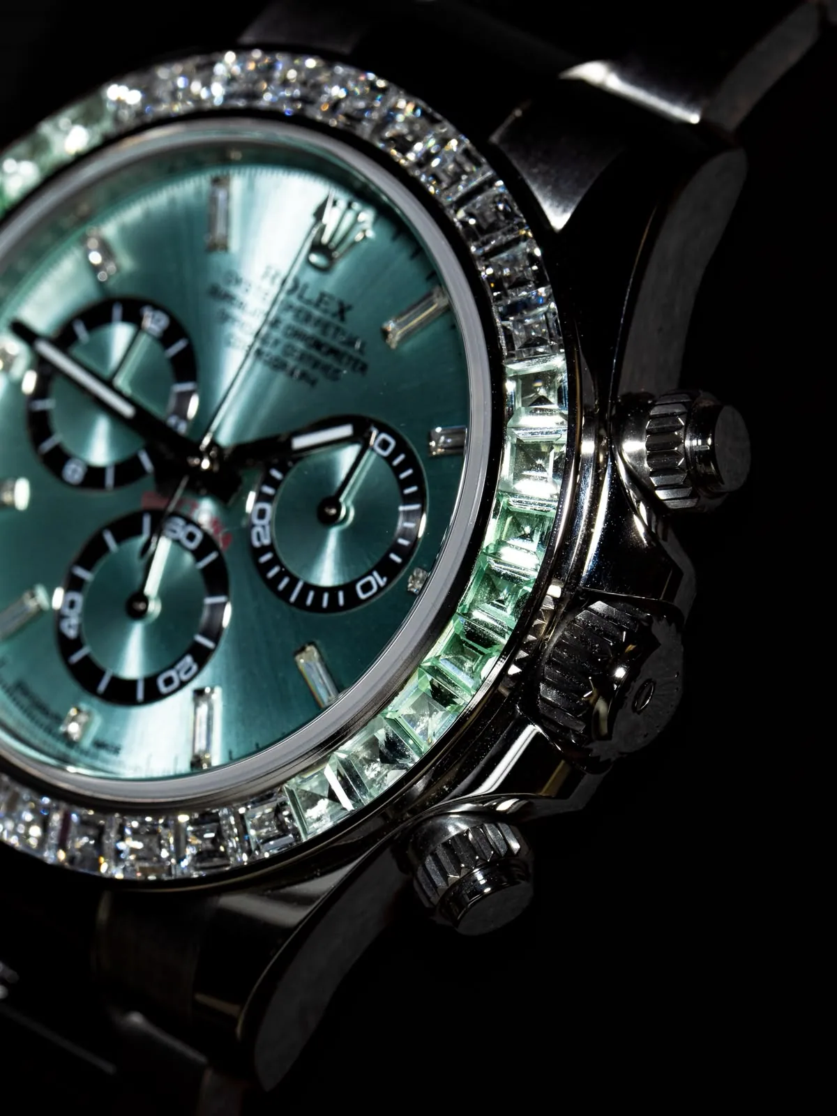 Close on the dial and the gem-set bezel, the chronograph counters in shadow.