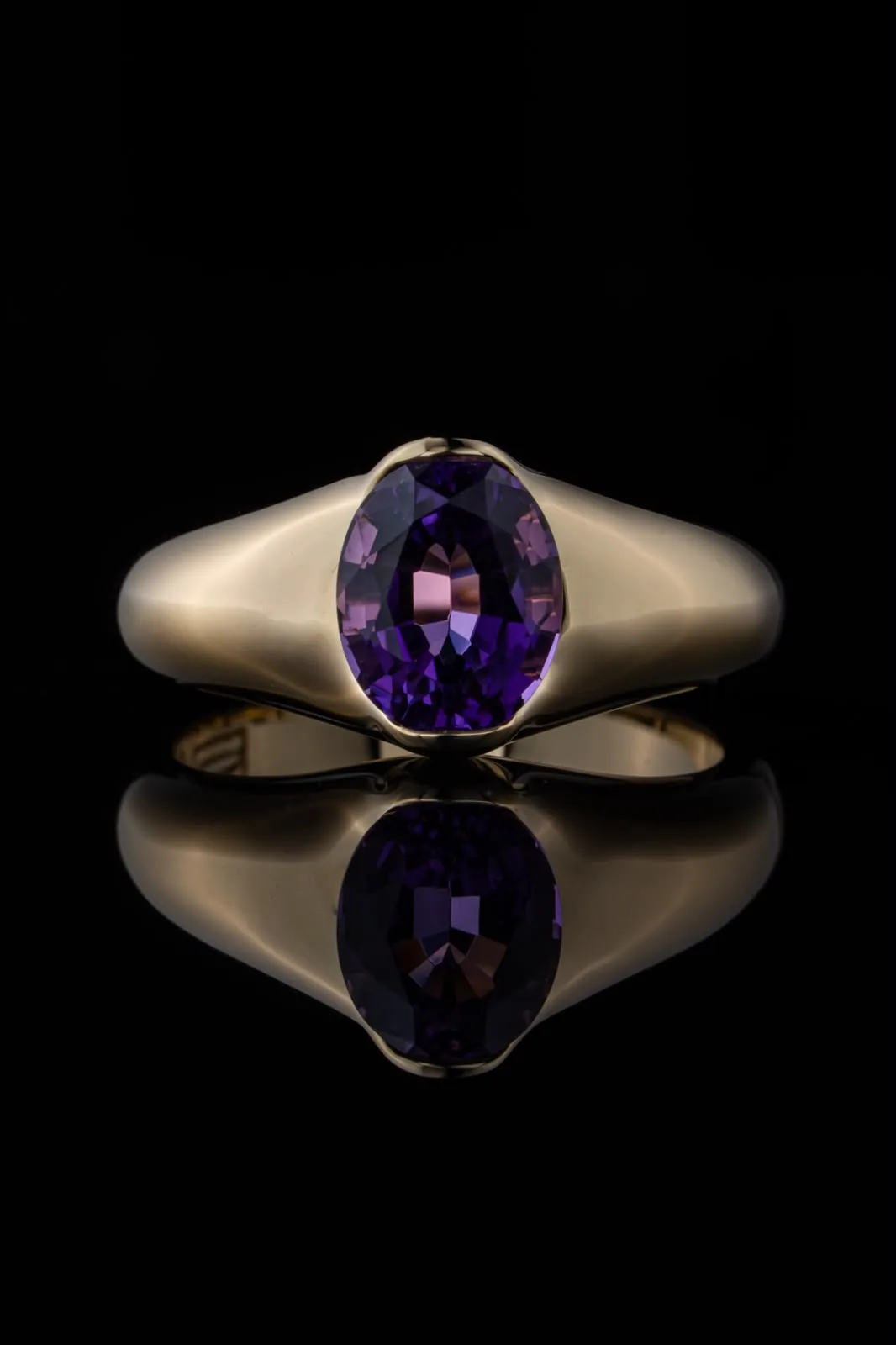 The ring seen from above, the oval stone framed by the rounded gold band.