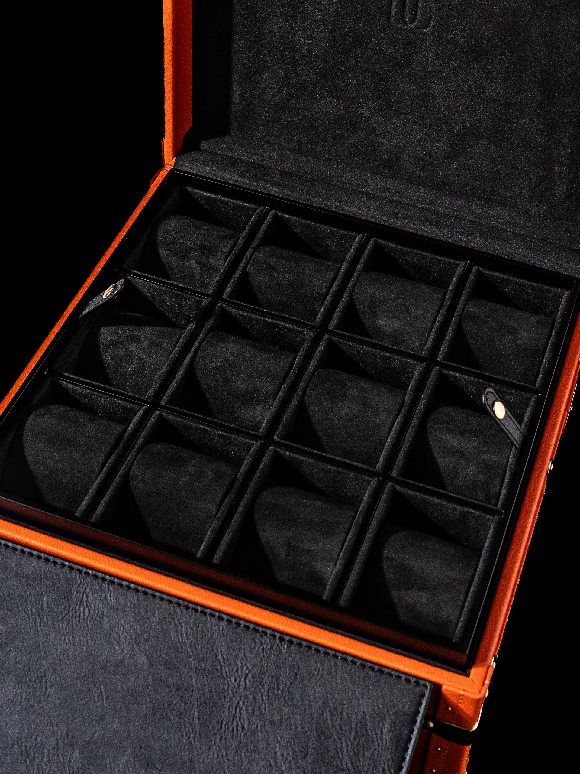 The trunk open, its interior fitted with a grid of dark compartments.