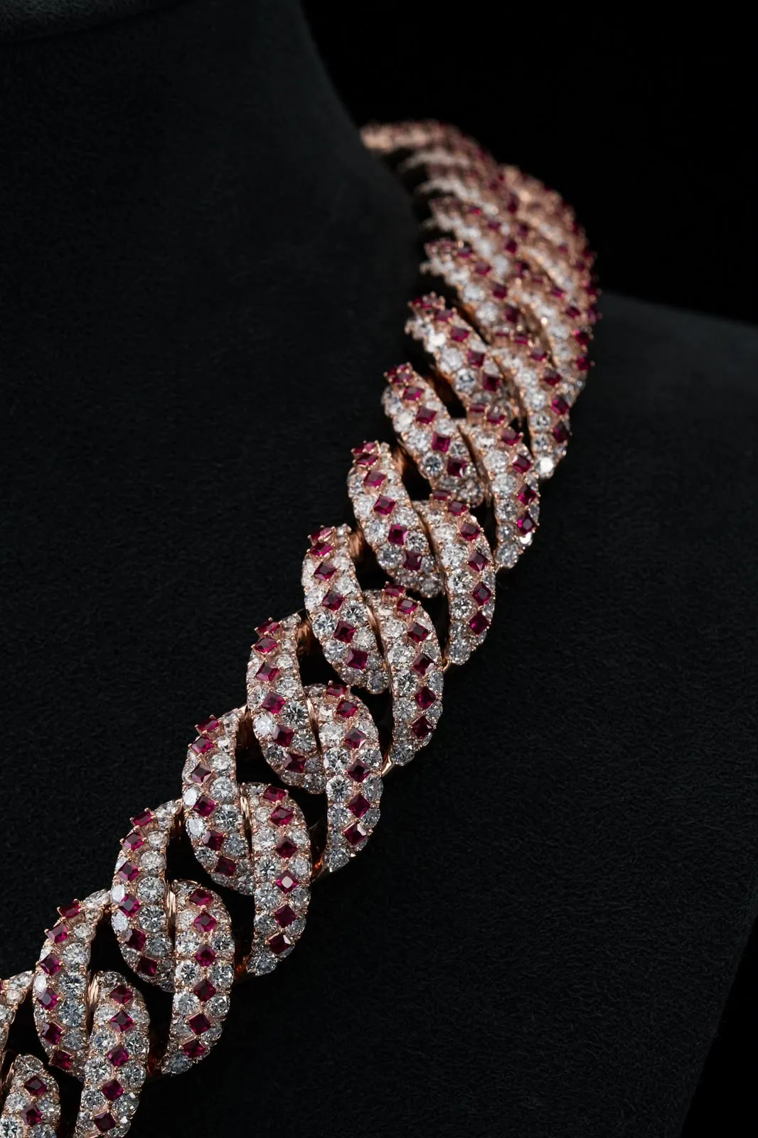 The chain seen along its curve, the pattern repeating into shadow.