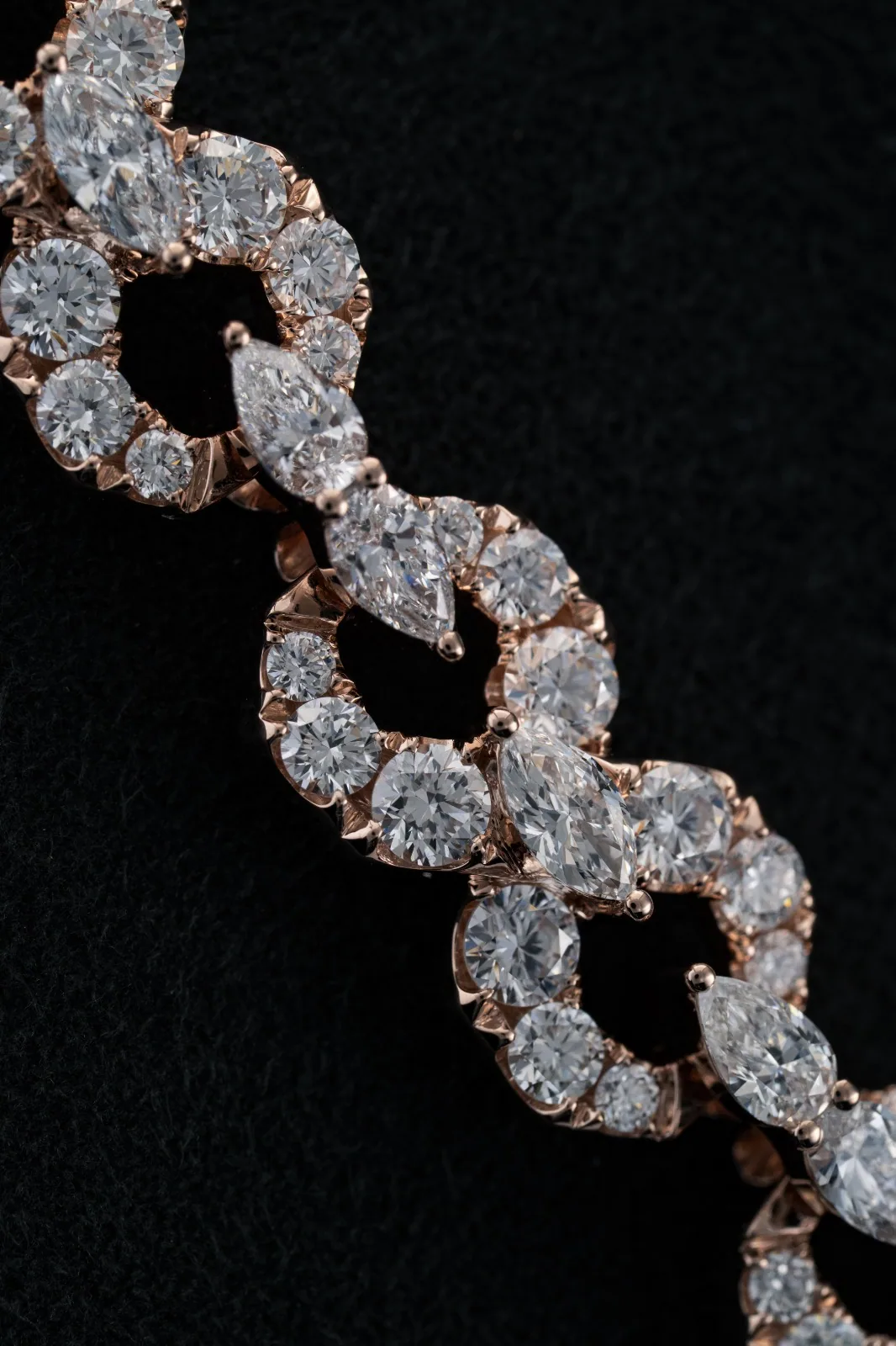 Close study of the interlaced links and the rose-gold claws holding each stone.