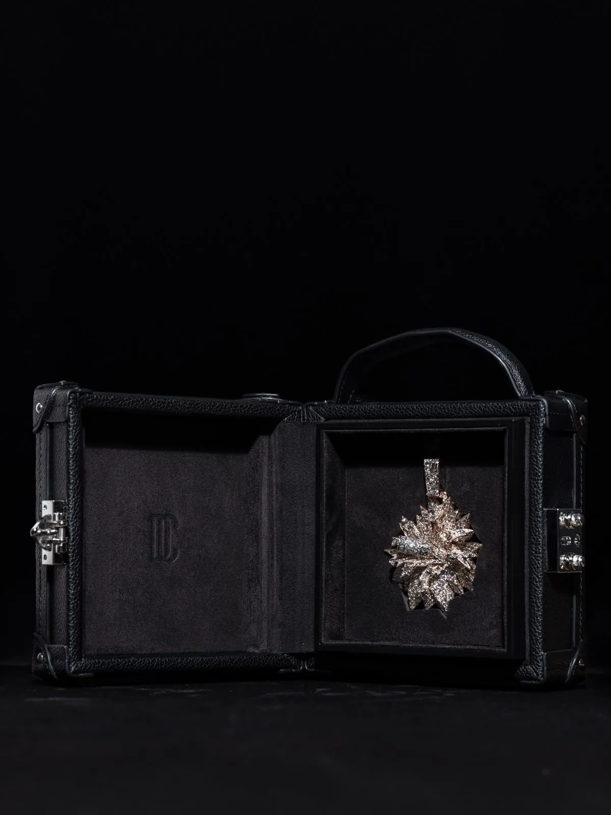 The écrin open flat, the pendant in the lid and the empty base beside it.