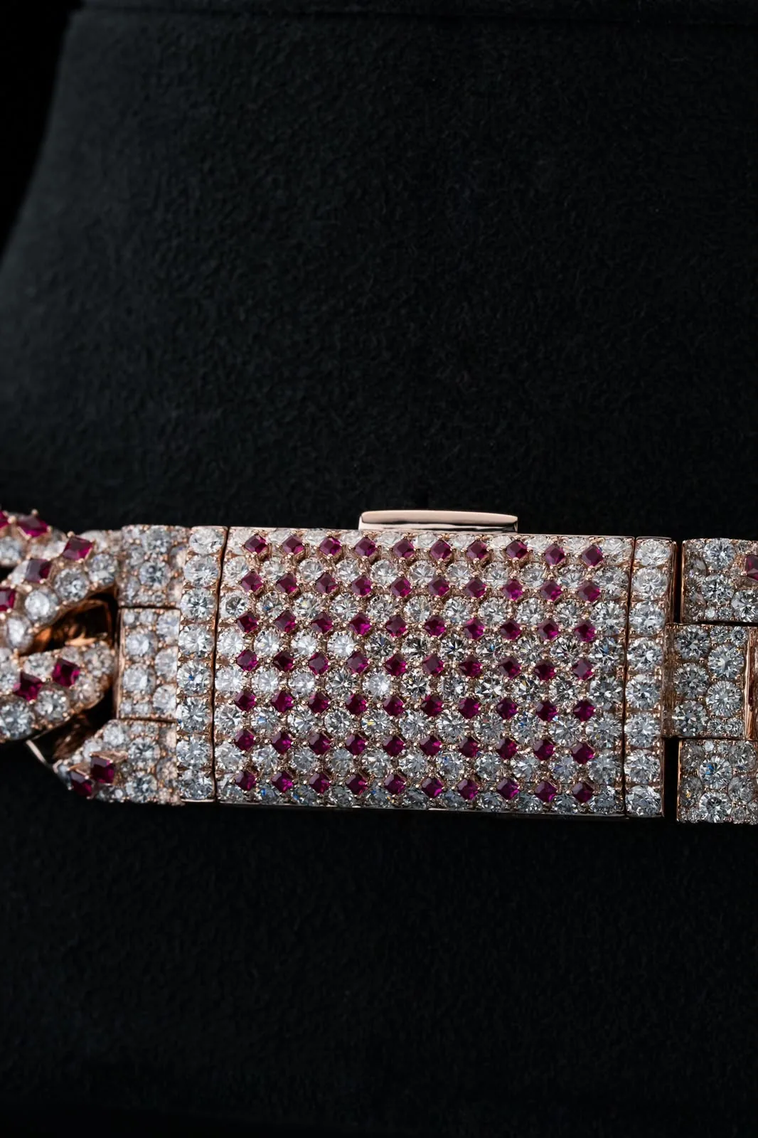 The clasp, paved in the same diamond and ruby rhythm as the links.
