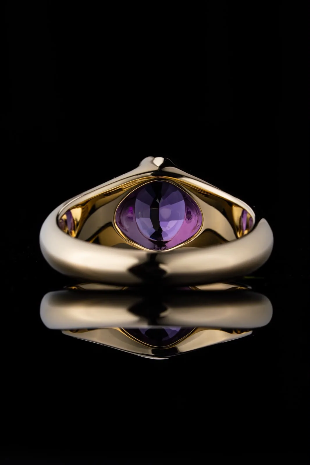 The ring head-on, the stone set low between the two ends of the band.