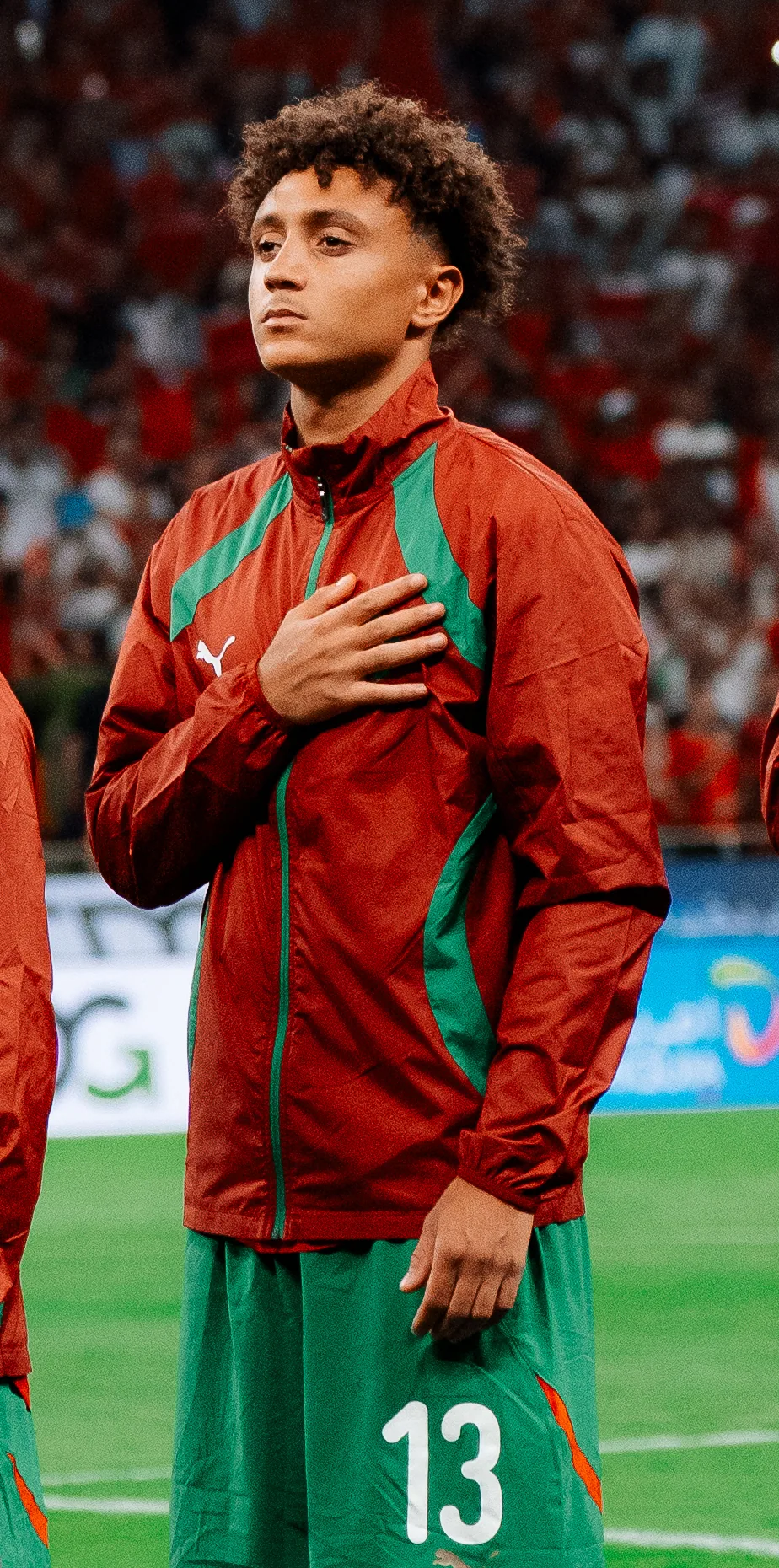 Eliesse Ben Seghir in a red Morocco jacket, his hand on his heart.