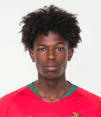 Félix Correia in a close portrait in a red Portugal shirt, looking into the camera.