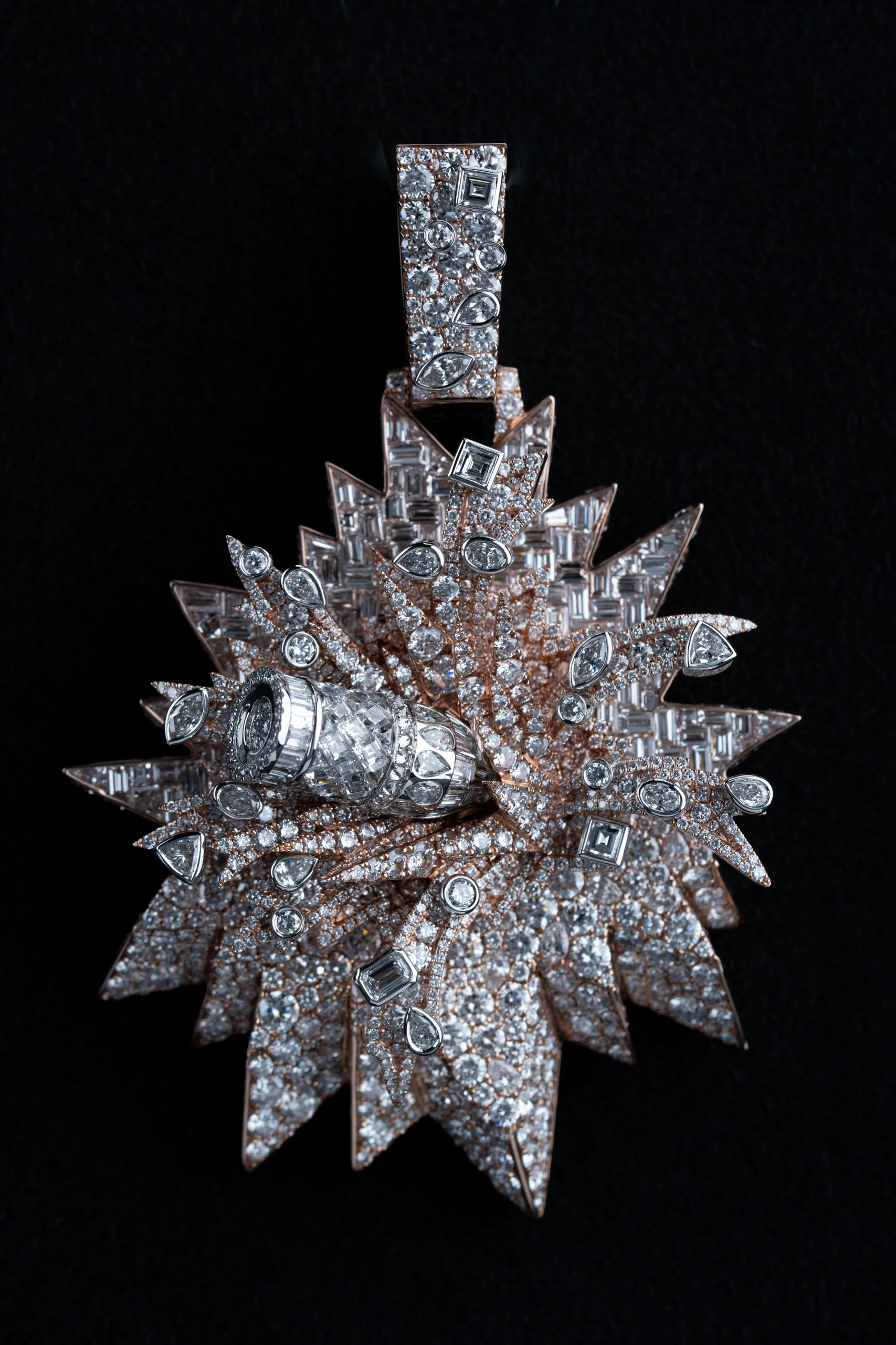 The bullet-fragment pendant in warm chiaroscuro light.