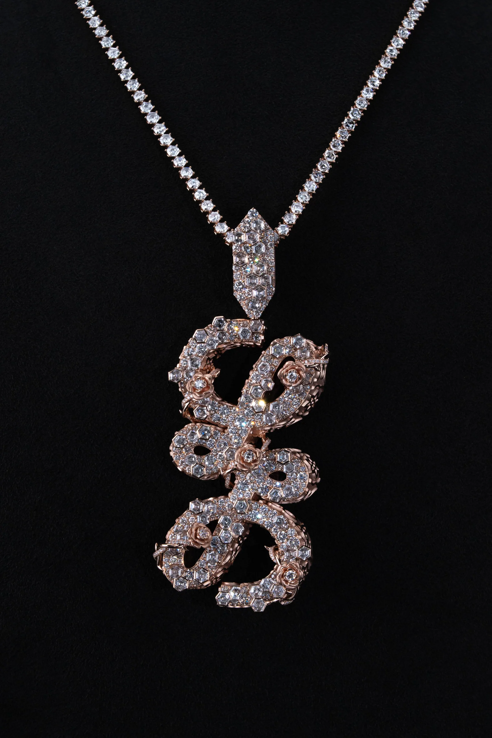 The 'LL' pendant lit from a single source against near-black.