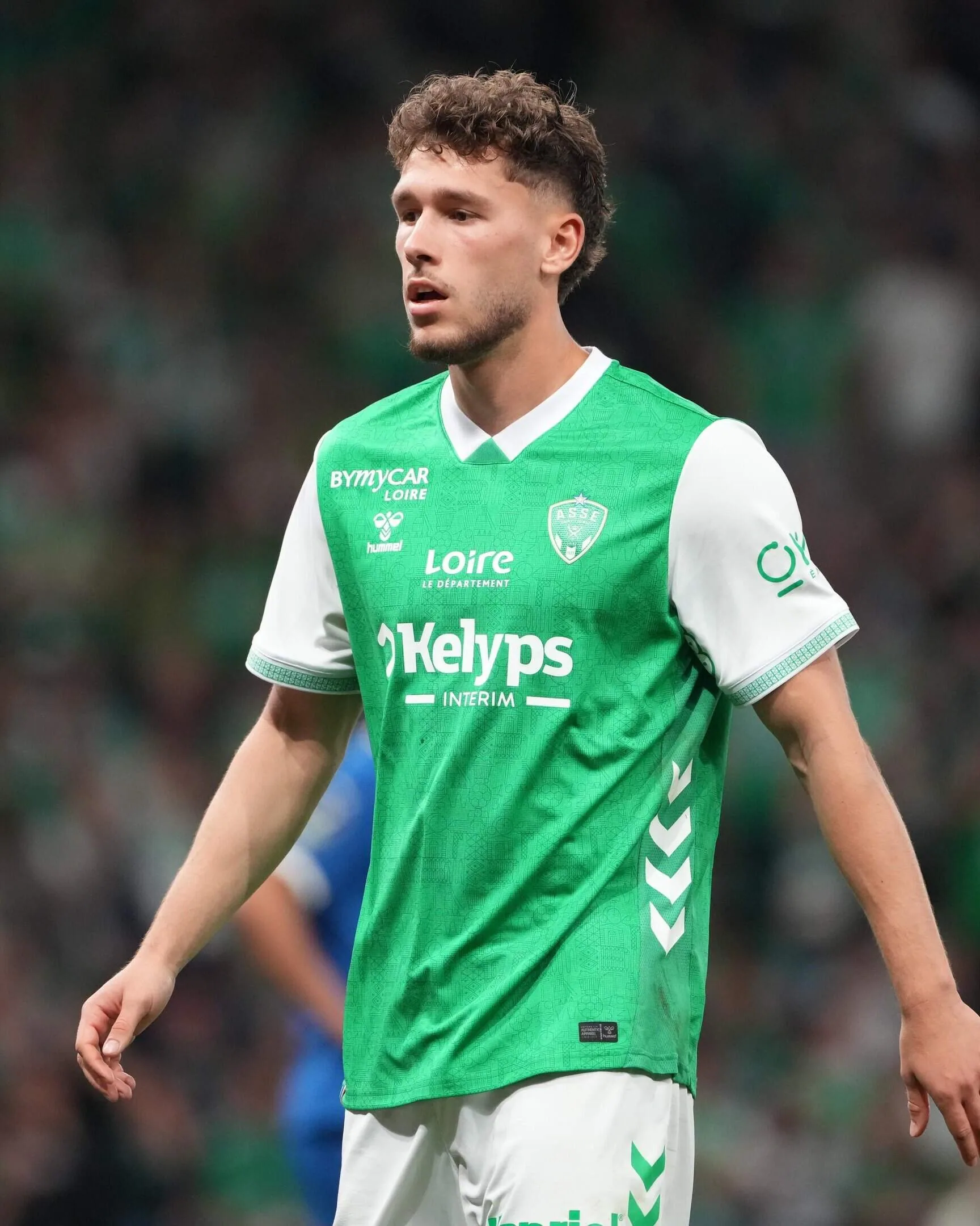Lucas Stassin in a green and white shirt, looking aside.