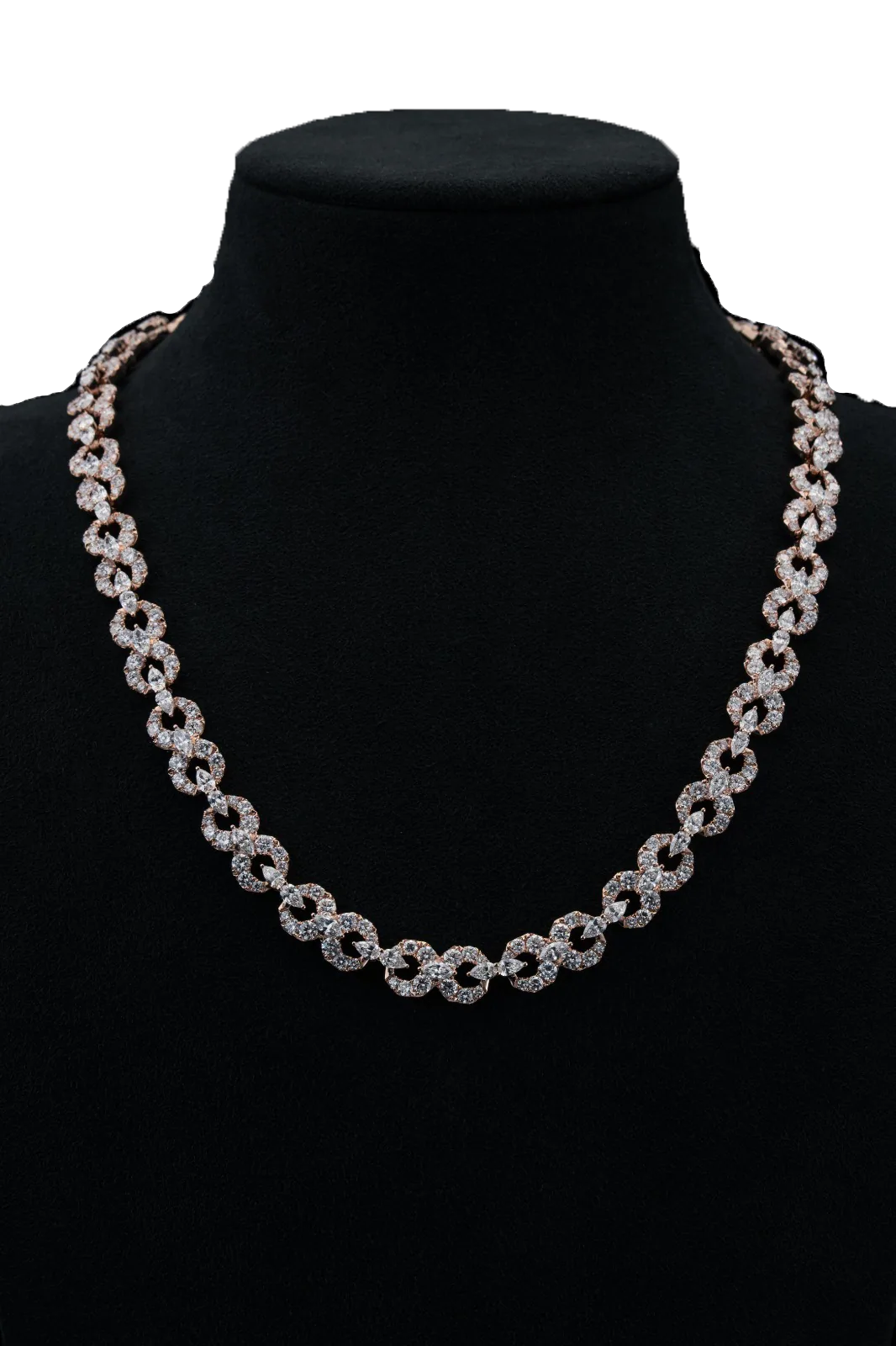 A rose-gold necklace of interlocking paved links on a black velvet bust, a single line of light around the neck.