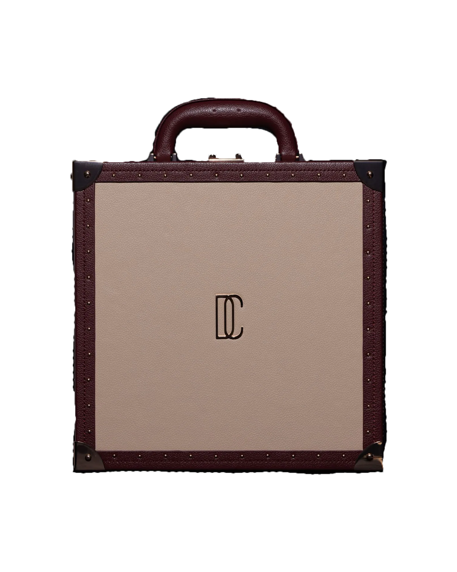 A flat trunk in burgundy and cream cut out against near-black, a gilt monogram at the centre of its panel.