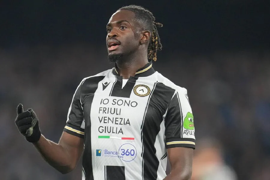 Oumar Solet in a black and white striped shirt, looking up and aside.